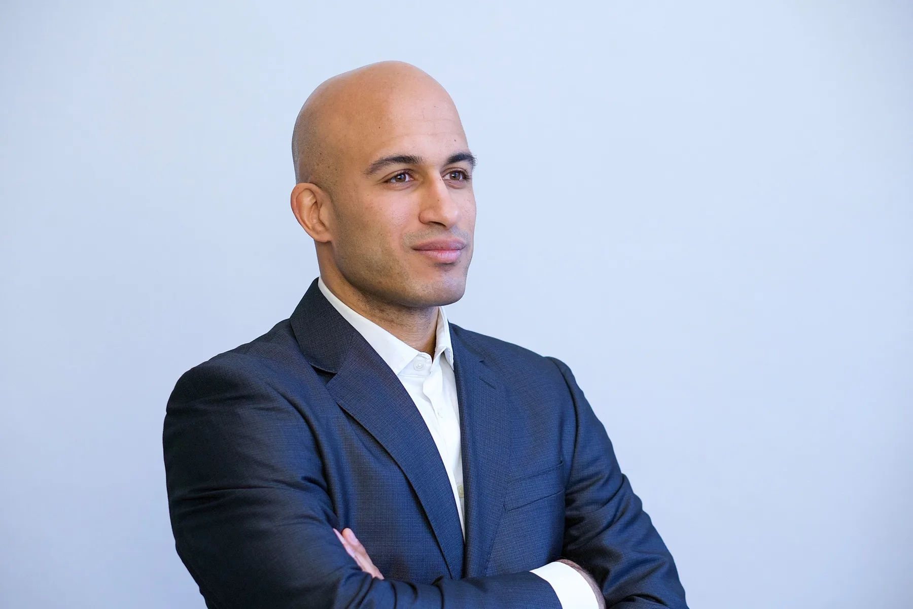 Dr. Karim Fathi im Anzug, mit verschränkten Armen